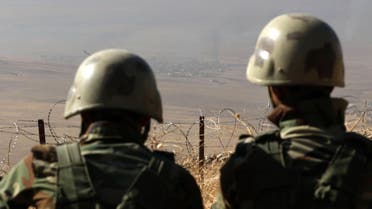 A picture taken from the top of Mount Zardak, about 25 kilometres east of Mosul, shows Iraqi Kurdish Peshmerga fighters watching smoke billowing during an operation against Islamic State (IS) group jihadists to retake the main hub of Mosul, on October 17, 2016. Thousands of Iraq's Kurdish peshmerga forces advanced on jihadist-held villages east of Mosul as part of a broad operation to retake the city from the Islamic State group. SAFIN HAMED / AFP