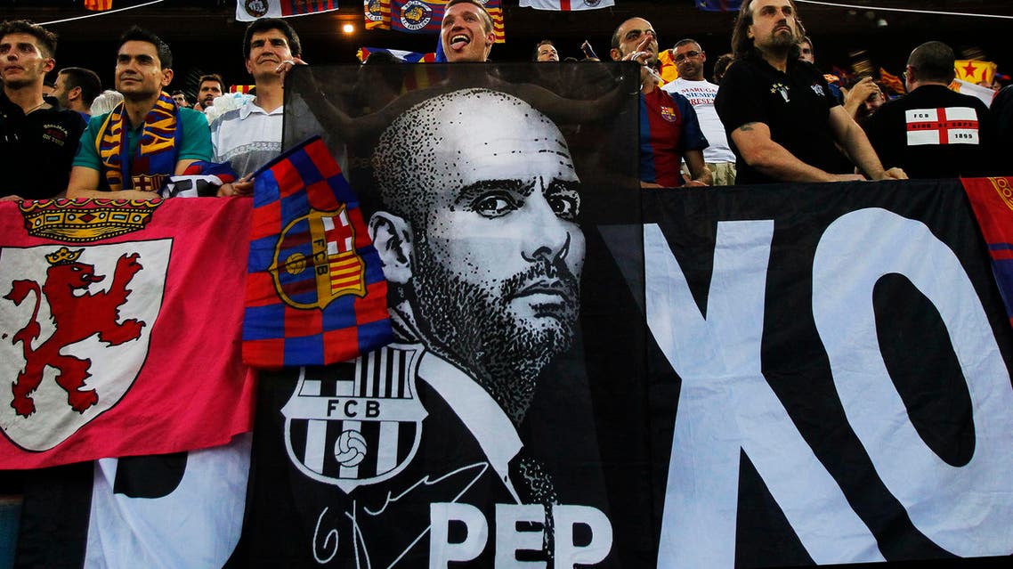 FC Barcelona's fans hold a banner of the team's coach Josep Guardiola and team flags during Copa del Rey soccer match final against Athletic Bilbao in Madrid, Spain, Friday, May 25, 2012. (AP