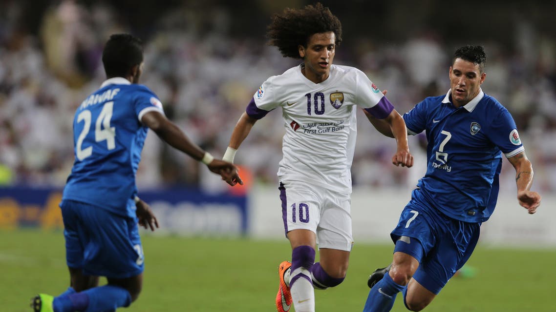 Omar Abdulrahman of UAE's Al Ain, center, battles for the ball with Neves Augusto Thiago of Saudi Arabia's Al Hilal, during a semifinal match of AFC Champions League in Al Ain, United Arab Emirates, Tuesday, Sept. 30, 2014. (AP