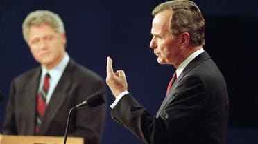 This photo from Oct. 12, 1992 shows Democratic presidential candidate Bill Clinton looking on at left, President George Bush speaks during the first presidential debate in St. Louis, Mo. (File Photo: AP/Bill Waugh)