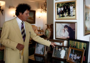 Gaddaf al-Dan poses next to a trove of photos of him and his late cousin Qaddafi. (Reuters)