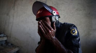 A Civil Defence member rubs his eyes as he tries to put out a fire inside a building after shelling in the rebel held besieged town of Douma, eastern Ghouta in Damascus. (Reuters)