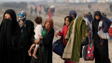 A newly displaced woman carries her child at a check point in Qayyara, east of Mosul, Iraq October 26, 2016. reuters