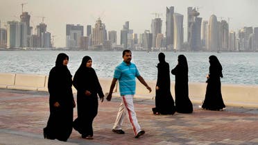 In this Saturday, April 7, 2012 file photo, the new high-rise buildings of downtown Doha, photographed in the background as Qatari women and a man walk by the sea in Doha, Qatar. A worker on a Qatar World Cup stadium site has died in the first work-related fatality to be announced by organizers of the 2022 soccer tournament which has been dogged by concerns about labor conditions. Qatar has previously reported three deaths at stadium construction sites but said they were not “work-related.” (AP Photo/Kamran Jebreili, File)