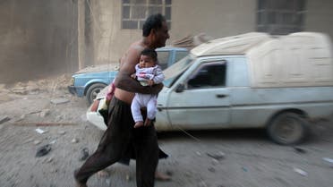 AFp A Syrian man carrying a child emerges from a dust cloud following a reported airstrike on Kafr Batna, in the rebel-held Eastern Ghouta area, on the outskirts of the capital Damascus, on September 30, 2016.