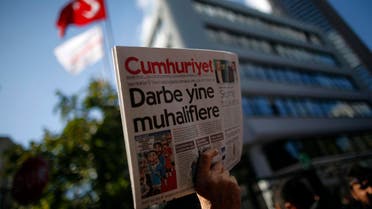 A man holds up the latest copy of Cumhuriyet outside its headquarters after Turkish police detained the chief editor and at least eight senior staff of Turkey's opposition Cumhuriyet newspaper in Istanbul, Monday, Oct. 31, 2016, amid growing fears over Turkey's widening crackdown on dissenting voices. AP