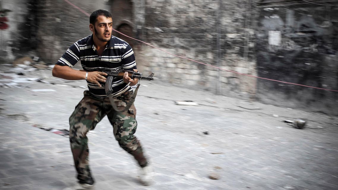 In this Sunday, Nov. 4, 2012 photo, a Free Syrian Army fighter fires his weapon while running for cover in the Bab al-Nasr district of Aleppo, Syria. (AP Photo/Mustafa Karali)