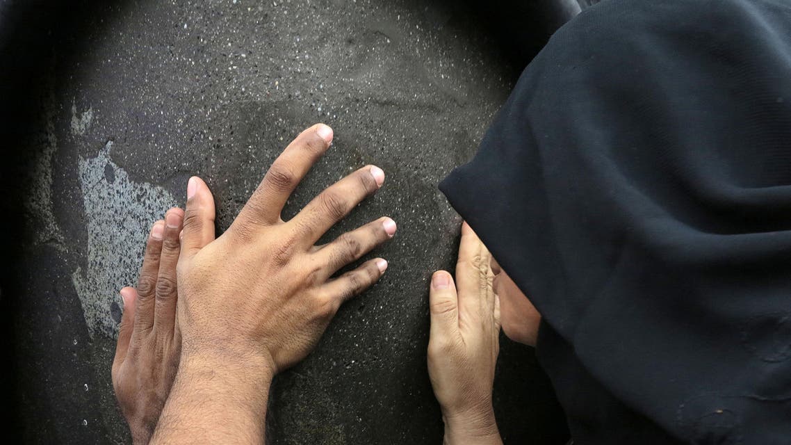 Worshippers touch the black stone of the Kaaba, the cube-shaped stone structure draped in black cloth that Muslims around the world face during daily prayers inside the Grand Mosque in the holy Muslim city of Mecca, Saudi Arabia, Monday, July 8, 2013. Mecca is regarded as the holiest city in the religion of Islam. (AP