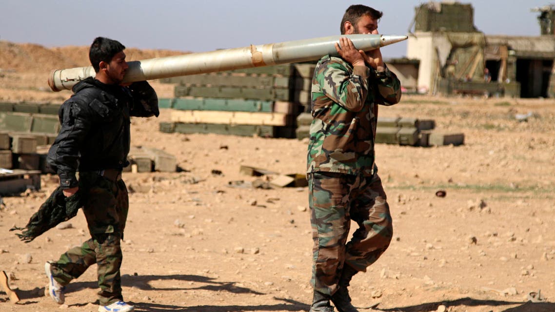 In this file photo taken on Wednesday, Feb. 17, 2016, soldiers from the Syrian army carry a rocket to fire at Islamic State group positions in the province of Raqqa, Syria. A two-pronged advance to capture key urban strongholds of the Islamic State, and the extremist group's self-styled capital of Raqqa has underlined a convergence of strategy between Washington and Moscow to defeat the extremist group, with Syria's Kurds emerging as the common denominator. (Alexander Kots/Komsomolskaya Pravda via AP, File)