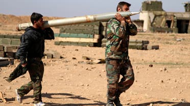 In this file photo taken on Wednesday, Feb. 17, 2016, soldiers from the Syrian army carry a rocket to fire at Islamic State group positions in the province of Raqqa, Syria. A two-pronged advance to capture key urban strongholds of the Islamic State, and the extremist group's self-styled capital of Raqqa has underlined a convergence of strategy between Washington and Moscow to defeat the extremist group, with Syria's Kurds emerging as the common denominator. (Alexander Kots/Komsomolskaya Pravda via AP, File)