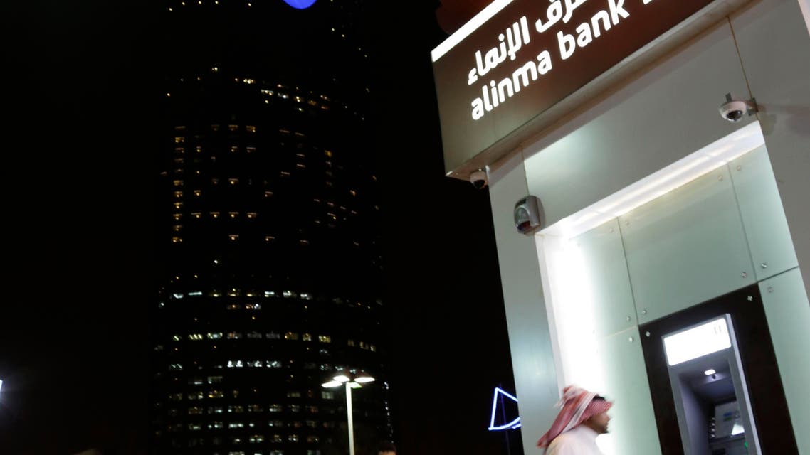 A Saudi man passes by a bank near the Kingdom Tower in Riyadh, Saudi Arabia. (AP)