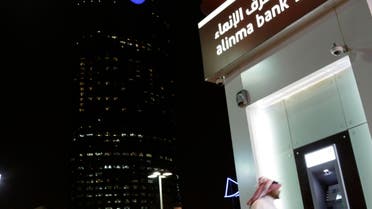A Saudi man passes by a bank near the Kingdom Tower  in Riyadh, Saudi Arabia. (AP)