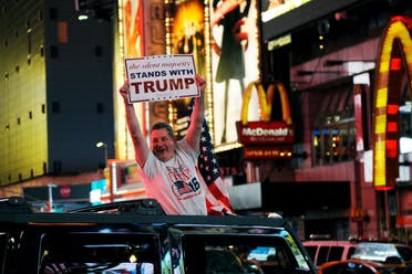 A man leans out of a Hummer shouting words in support of U.S. Republican presidential nominee Donald Trump while driving through Times Square in New York, U.S., November 9, 2016. (Reuters)