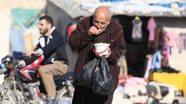A man eats food that was distributed as aid in a rebel-held besieged area in Aleppo, Syria November 6, 2016. (Reuters) 