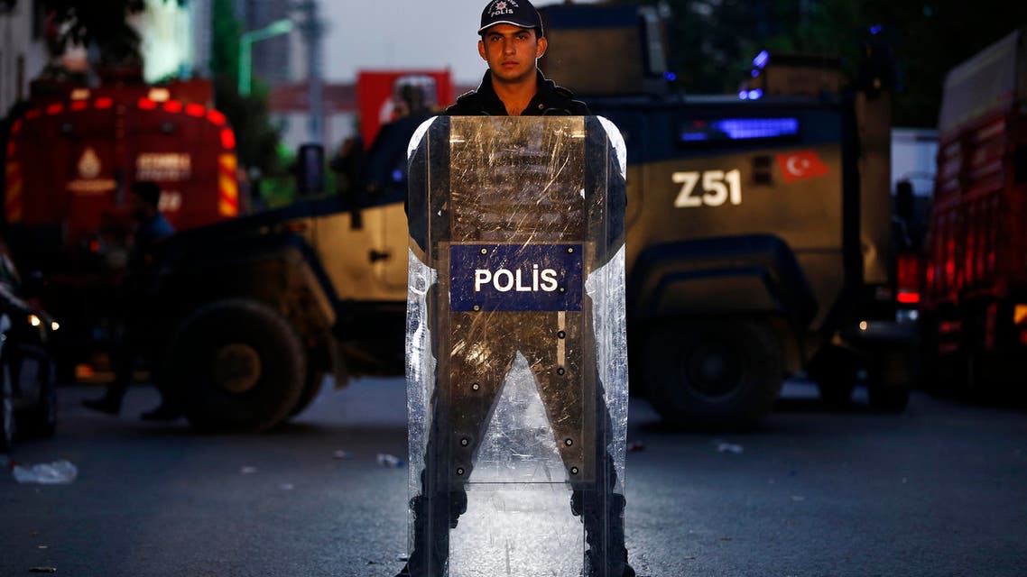 A Turkish police officer stands behind his shield as he secures the scene of a blast in Istanbul, Thursday, Oct. 6, 2016. AP