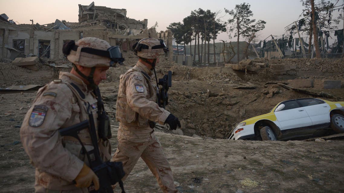 Croatian soldiers from the NATO coalition are walking past a crater from a bomb blast as they inspect the site of an attack targeting the German consulate in Mazar-i-Sharif on November 11, 2016. afp