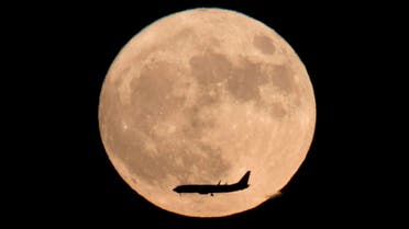 A jet plane flies across the moon seen from Beijing, China, Monday, Nov. 14, 2016. The brightest moon in almost 69 years lights up the sky on Monday in a treat for star watchers around the globe. The phenomenon is known as the supermoon. (AP)