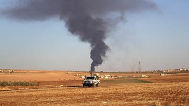 Rebel fighters ride a military vehicle near rising smoke from al-Bab city, northern Aleppo province. (Reuters)