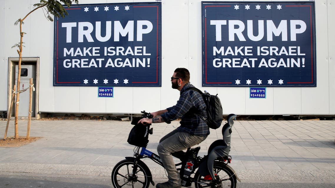 A man cycles past signs bearing the name of U.S. President-elect Republican Donald Trump in Tel Aviv, Israel November 14, 2016. REUTERS