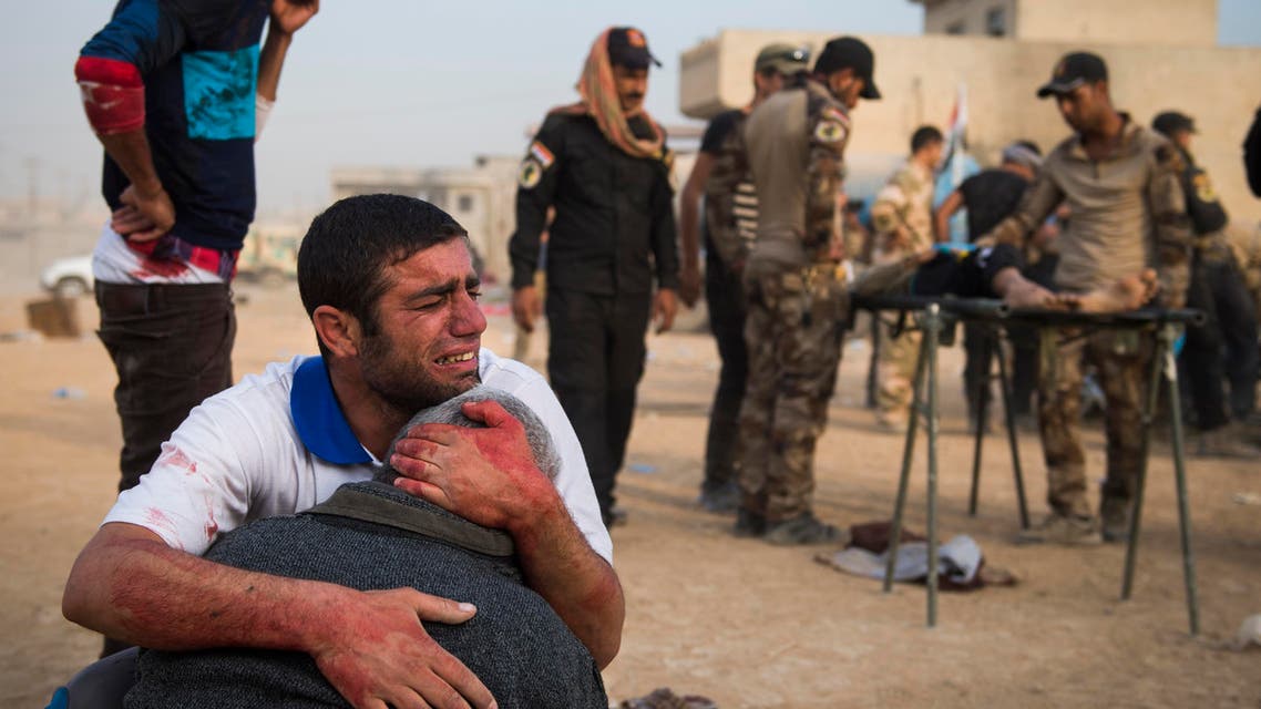 Father and grandfather of 15-year-old Shafiq mourn as Iraqi forces surround his body at an outdoor field clinic in the Samah neighbourhood in Mosul on November 13, 2016. A double barreled mortar attack killed Shafiq and seriously injured his 12-year-old neighbour Mohammed as Iraqi Special Forces 2nd division continued to battle IS forces as they pushed through the Arbagiah area and into the neigbourhood of Karkukli. Odd ANDERSEN / AFP