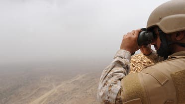 A Saudi soldier looks through binoculars from a position at al-Dokhan mountain, on the Saudi-Yemeni border, in southwestern Saudi Arabia, on April 13, 2015. AFP