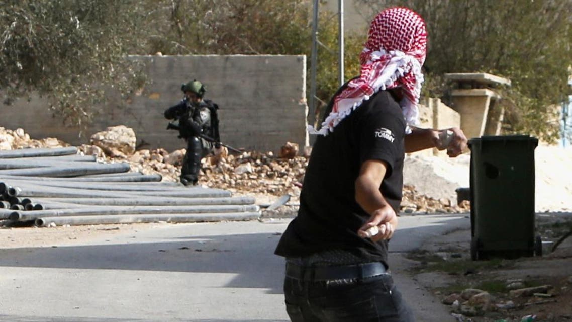 Israeli security forces aim their weapons towards Palestinian protestors throwing rocks during clashes on November 18, 2016. (Jaafar Ashtiyeh/AFP)