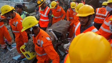 Rescue workers remove the remains of a passenger from the site of a train derailment in Pukhrayan, south of Kanpur city, India. (Reuters)