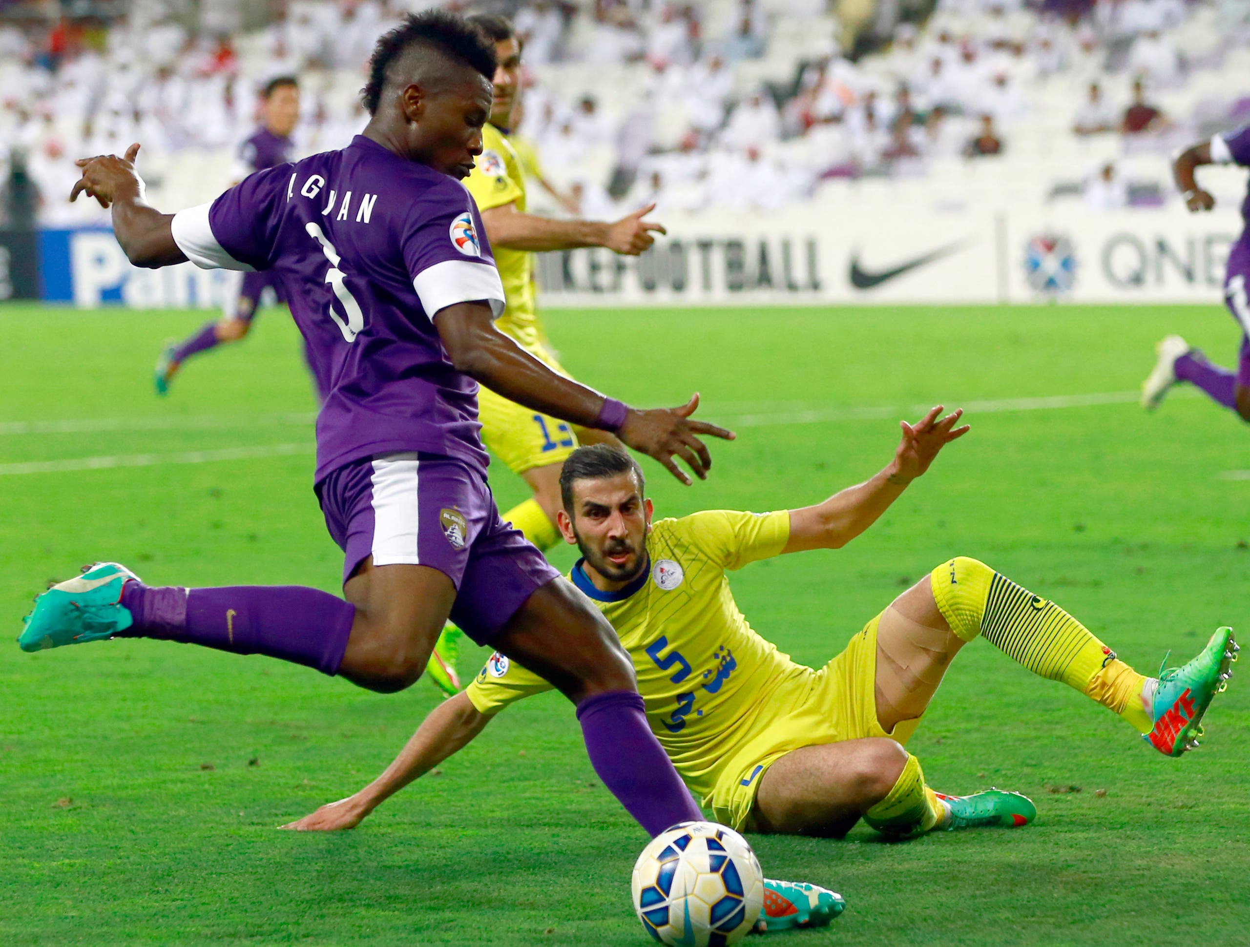 Al-Ain's Asamoah Gyan (L) fights for the ball with Naft's Amin Hajmohammadi (R) during their AFC Champions League Group B football match Iran's Naft Tehran against UAE's Al-Ain at Sheik Hazza Bin Zayed stadium on May 6, 2015 in Al-Ain. AFP