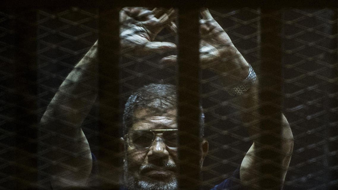 A file picture taken on June 2, 2015 shows ousted Egyptian president Mohamed Morsi gesturing from the defendants’ cage as he attends his trial at the police academy on the outskirts of the capital Cairo. (AFP)