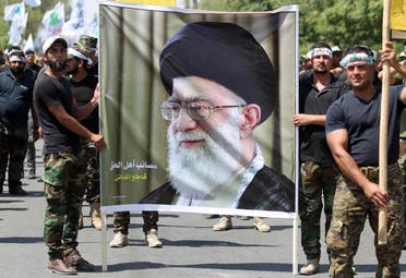 Iraqi pro-government forces hold a poster bearing a portrait of Iran's supreme leader Ayatollah Ali Khamenei as they take part in a parade marking al-Quds Day in Baghdad, on July 1, 2016. (AFP)