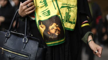 A woman wears a scarf decorated in the colours of Lebanon's Shiite Hezbollah movement and bearing a picture of the movement's leader Hassan Nasrallah as she takes part in commemorations marking Ashura in a Beirut southern suburb on October 12, 2016. Ashura mourns the death of Imam Hussein, a grandson of the Prophet Mohammed, who was killed by armies of the Yazid near Karbala in 680AD. PATRICK BAZ / AFP