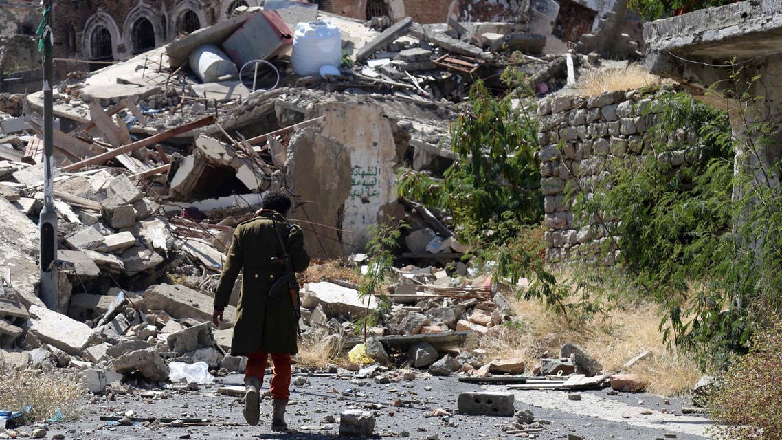 A Yemeni man inspects the damage on a street following clashes between pro-government militants, loyal to President Abedrabbo Mansour Hadi, and Houthi rebels on November 22, 2016 in Taiz. (AFP)