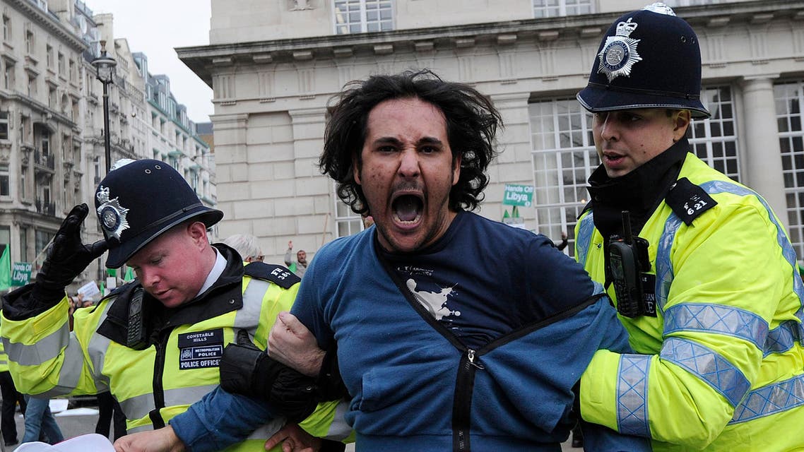 A protestor (C) is led away by police while taking part in a pro-Qaddafi demonstration in London, on March 29, 2011. (AFP)