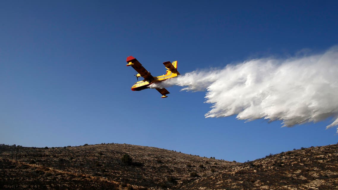 A foreign firefighting plane helps extinguish a fire as it flies over the village of Nataf close to Jerusalem, as it helps extinguish an ongoing fire in the area, on November 26, 2016. Wildfires near Jewish settlements in the occupied West Bank have forced hundreds to flee their homes, after mass evacuations in Israel and more than a dozen arrests, police said, while Israeli and Palestinian firefighters, helped by foreign aircraft, have been battling dozens of bush blazes fed by drought and high winds that have seen tens of thousands of people evacuated. AHMAD GHARABLI / AFP