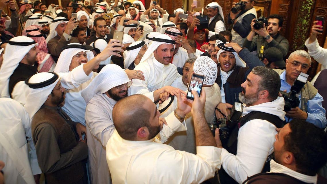 Kuwaiti candidate and former parliament speaker Marzouq al-Ghanem (C), celebrates with his supporters following his victory. (AFP)