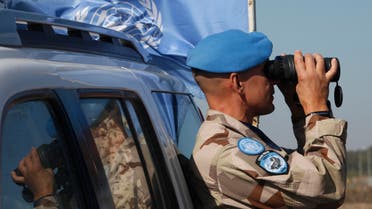 A UN member looks through binoculars to monitor the Israel-Syria border in the Israeli-annexed Golan Heights, on November 27, 2016, following an attack by gunmen linked to the Islamic State (IS) group. Israeli forces killed four gunmen linked to the Islamic State group after they fired on soldiers, the military said, in the first such attack on the occupied Golan Heights. AFP