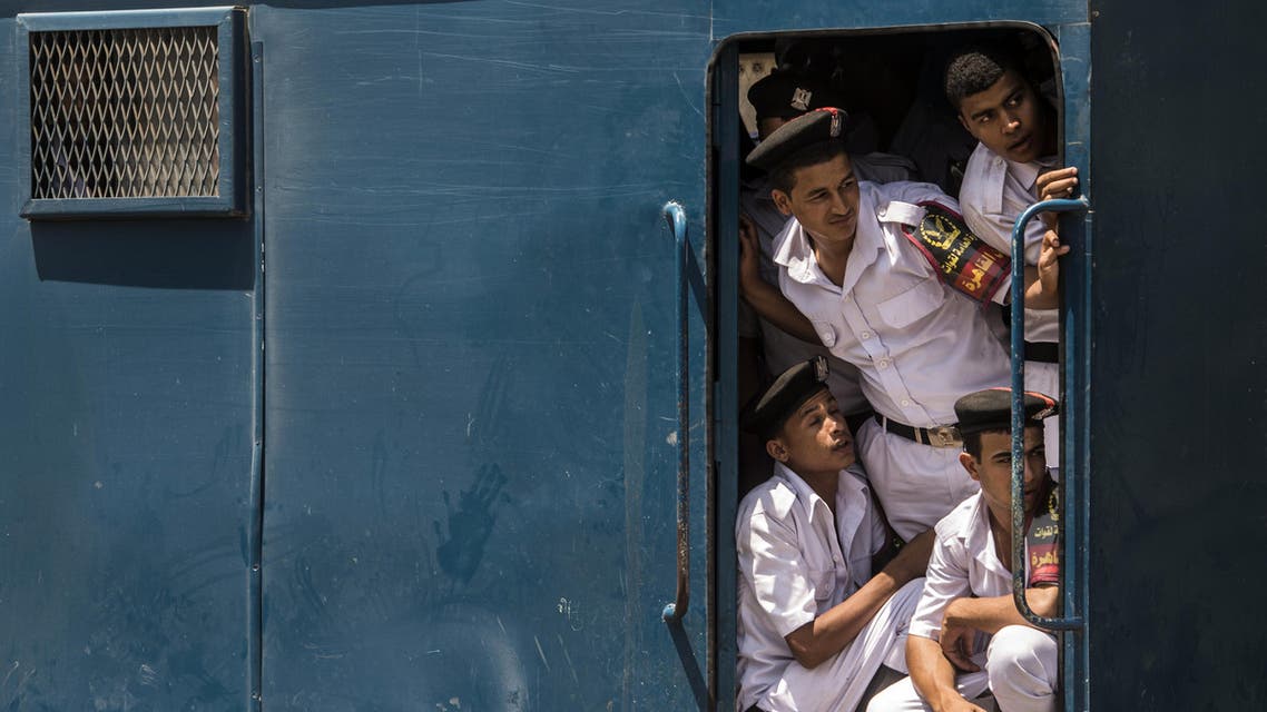 Egyptian policemen look-out from a police vehicle parked during the arrival of the body of nobel prize-winning Egyptian-American chemist Ahmed Zewail, at Cairo airport on August 6, 2016. Zewail, who served as a science and technology advisor to US President Barack Obama, died on August 6, 2016 in the United States. He was 70. AFP