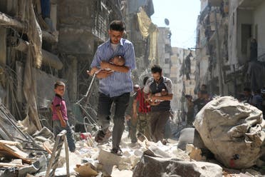Syrian men carrying babies make their way through the rubble of destroyed buildings following a reported air strike on the rebel-held Salihin neighbourhood of the northern city of Aleppo, on September 11, 2016. Air strikes have killed dozens in rebel-held parts of Syria as the opposition considers whether to join a US-Russia truce deal due to take effect on September 12. AMEER ALHALBI / AFP