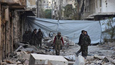 Syrian government soldiers walk amid rubble of damaged buildings, near a cloth used as a cover from snipers, after they took control of al-Sakhour neighborhood in Aleppo, Syria in this handout picture provided by SANA on November 28, 2016.