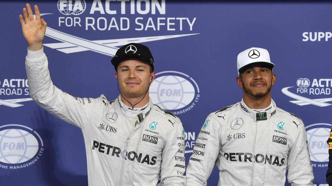 Mercedes AMG Petronas F1 Team's British driver Lewis Hamilton (C), flanked by his German teammate Nico Rosberg (L) and Infiniti Red Bull Racing's Australian driver Daniel Ricciardo, celebrate at the end of the qualifying session as part of the Abu Dhabi Formula One Grand Prix at the Yas Marina circuit on November 26, 2016. Lewis Hamilton will start on pole for the Abu Dhabi Grand Prix title showdown after the defending champion bettered his Mercedes teammate Nico Rosberg in qualifying. Red Bull's Daniel Ricciardo came in third to start on the second row at Yas Marina where the Australian is joined by the Ferrari of Kimi Raikkonen. Andrej ISAKOVIC / AFP