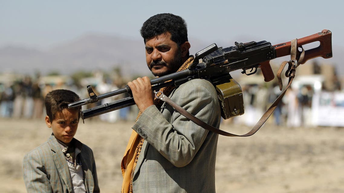 A Yemeni Huthi fighter carrying his weapon stands next to a child during a gathering to mobilise more fighters into several battlefronts on November 1 ,2016 on the outskirts of the capital Sanaa. The war in Yemen escalated in March 2015 when the Saudi-led coalition launched a military campaign to push back the Huthi rebels, after they seized the capital in 2014 and then advanced on other parts of Yemen. MOHAMMED HUWAIS / AFP