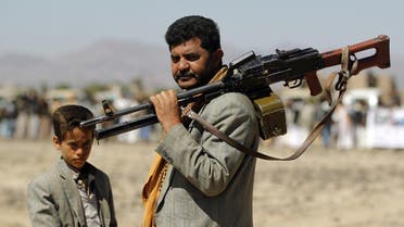 A Yemeni Huthi fighter carrying his weapon stands next to a child during a gathering to mobilise more fighters into several battlefronts on November 1 ,2016 on the outskirts of the capital Sanaa. The war in Yemen escalated in March 2015 when the Saudi-led coalition launched a military campaign to push back the Huthi rebels, after they seized the capital in 2014 and then advanced on other parts of Yemen.   MOHAMMED HUWAIS / AFP