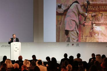 Director of the Arab Regional Centre for World Heritage, Mounir Bouchenaki speaks in front of a giant screen during the opening ceremony of a conference gathering officials and experts from around the world gather to discuss forming a global alliance to protect endangered heritage sites on December 2, 2016 in Abu Dhabi. afp
