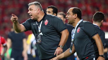 UAE's Al-Ahli Romanian manager Cosmin Olaroiu (L) shouts instructions to his players during the first leg match of the AFC Champions League football final against China's Guangzhou Evergrande at the Rashid Stadium in Dubai on November 7, 2015. The second leg of the final will take place on November 21 in China. AFP PHOTO / MARWAN NAAMANI  MARWAN NAAMANI / AFP
