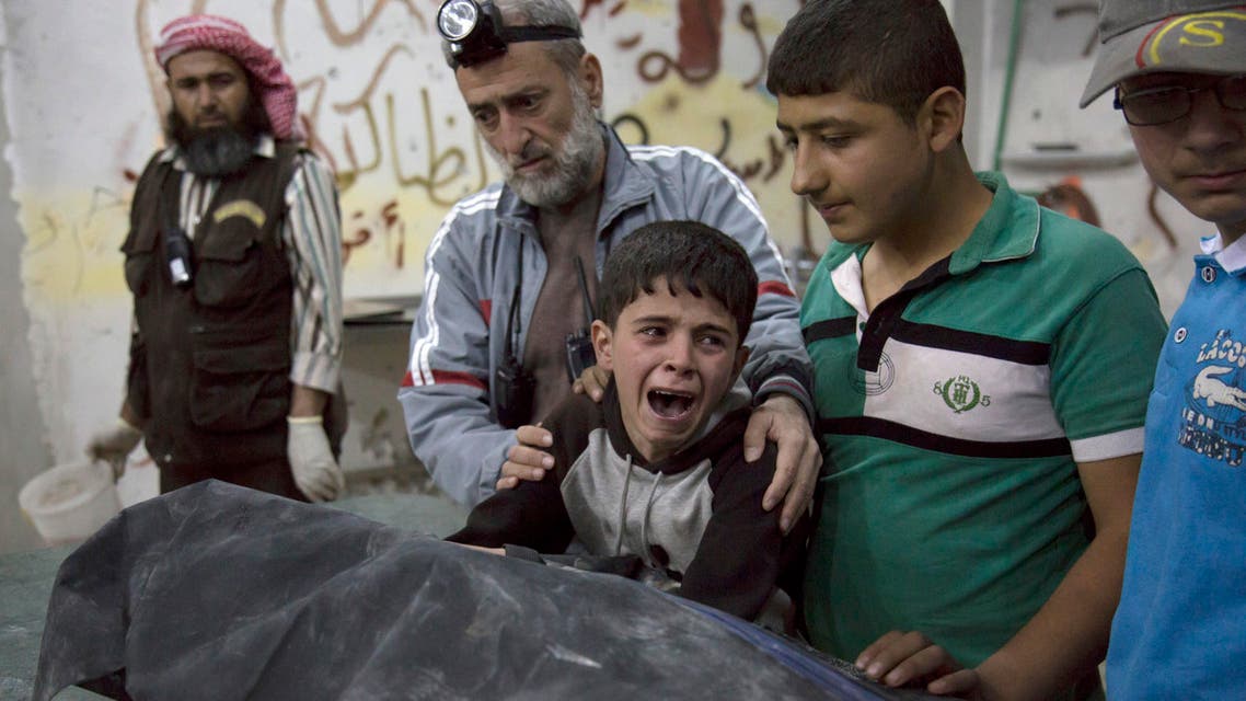 A Syrian boy is comforted as he cries next to the body of a relative who died in a reported airstrike on April 27, 2016 in the rebel-held neighbourhood of al-Soukour in the northern city of Aleppo. KARAM AL-MASRI / AFP
