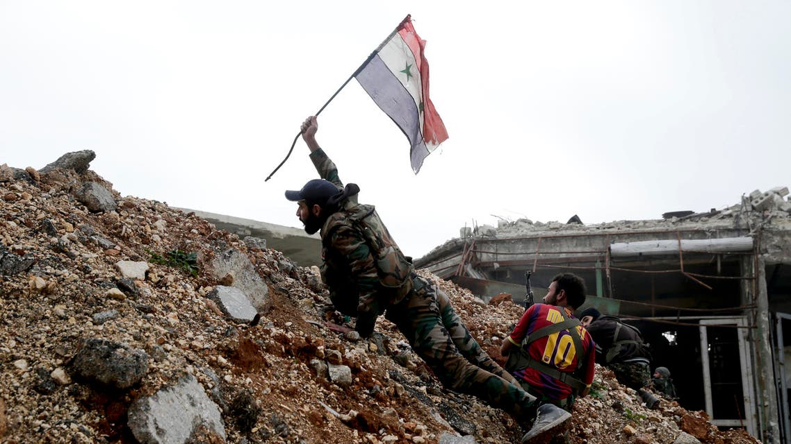 A Syrian army soldier places a Syrian national flag during a battle with rebel fighters at the Ramouseh front line, east of Aleppo, Syria, Monday, Dec. 5, 2016. The government seized large swathes of the Aleppo enclave under rebel control since 2012 in the offensive that began last week. The fighting was most intense Monday near the dividing line between east and west Aleppo as government and allied troops push their way from the eastern flank, reaching within less than a kilometer (half a mile) from the citadel that anchors the center of the city. (AP Photo/Hassan Ammar)