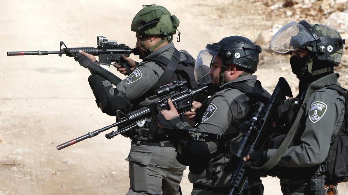 Israeli security forces aim their weapons towards Palestinian protestors during clashes following the weekly demonstration against the expropriation of Palestinian land by Israel in the village of Kfar Qaddum, near Nablus, in the occupied West Bank, on November 18, 2016.