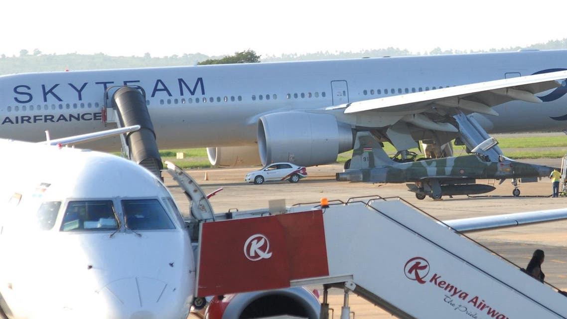 In this photo of Sunday, Dec. 20, 2015, A Kenyan military jet parked next to AirFrance plane, background, which made emergency landing at Moi International Airport on Saturday, in Mombasa, Kenya, Sunday, Dec. 20, 2015. A retired French police officer traveling on Air France was detained Monday after a fake bomb hidden in a lavatory forced his Paris-bound flight to make an emergency landing in Kenya, according to prosecutors. The hoax, the fourth against Air France in recent weeks, comes amid heightened concerns about extremist violence in many countries, and aggravated passenger jitters around the holidays.(AP Photo) Use Information This content is intended for editorial u