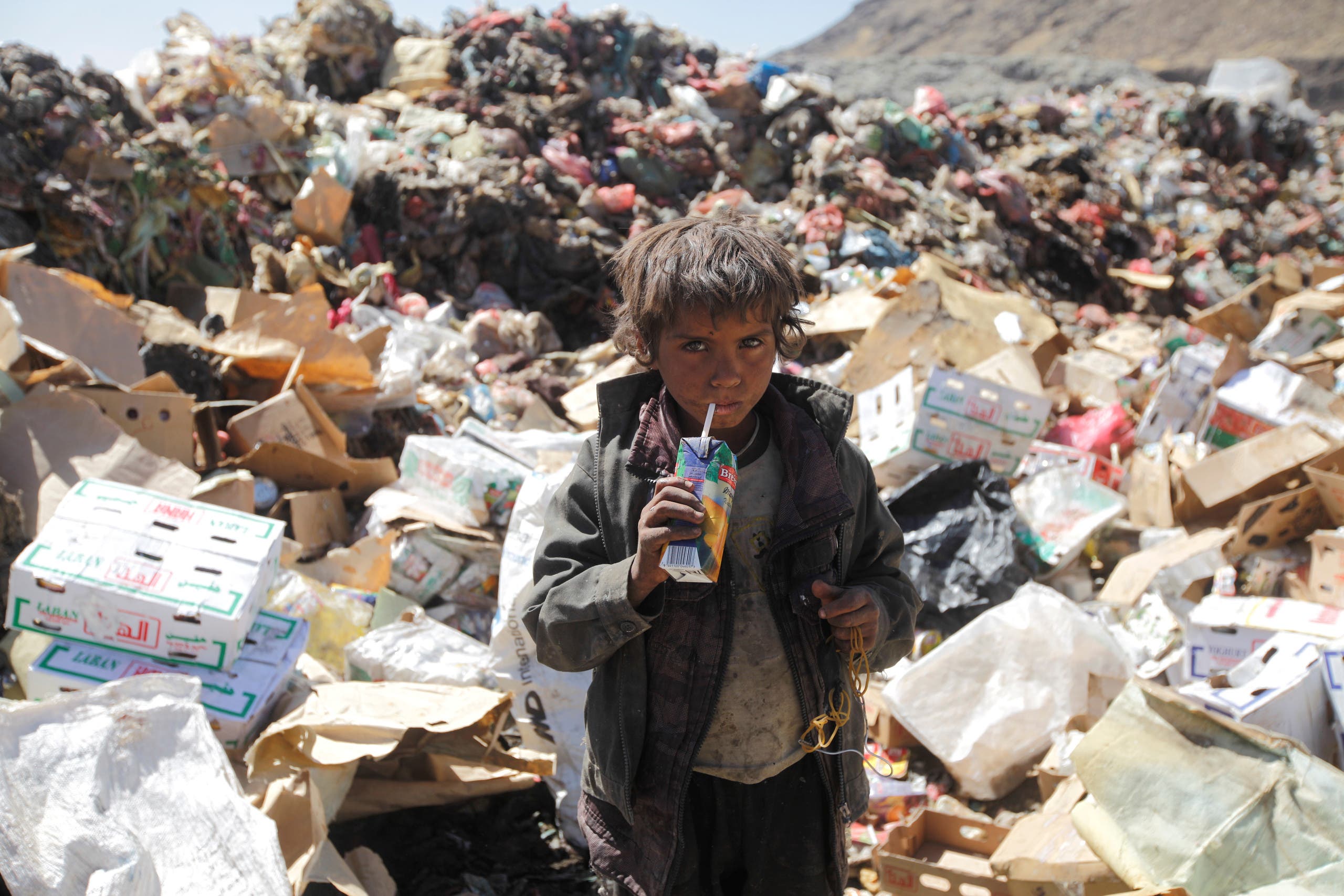 A boy drinks expired juice on a pile of rubbish at landfill site on the outskirts of Sanaa, Yemen November 16, 2016. (Reuters)