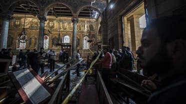 Egyptian security forces (L) inspect the scene of a bomb explosion at the Saint Peter and Saint Paul Coptic Orthodox Church on December 11, 2016, in Cairo's Abbasiya neighbourhood. The blast killed at least 25 worshippers during Sunday mass inside the Cairo church near the seat of the Coptic pope who heads Egypt's Christian minority, state media said. KHALED DESOUKI / AFP
